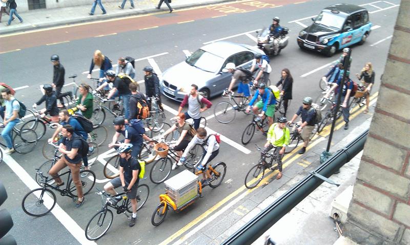 A group of cyclists stopping at a road junction
